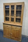 A VICTORIAN PINE BOOKCASE, with double glazed doors, flanking a glazed panel, over a base with two