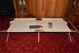 A MIXED LOT OF MILITARIA, to include an army bed, a whistle, pump, tankard and cap badge, the bed