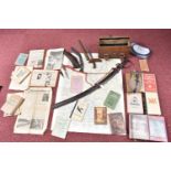 A BOX CONTAINING SOME TOURIST STYLE KNIVES, also include is a sword, German books , a doctors bag