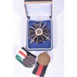 A WWII ERA KNIGHT CROSS WITH SWORDS AND TWO MEDALS, the knight cross appears to be painted over on