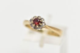 A 9CT GOLD GARNET AND PASTE CLUSTER RING, the principal garnet, within a colourless paste