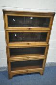 AN EARLY 20TH CENTURY OAK KENRICK & JEFFERSON FOUR TIER BOOKCASE, with hide and fall glazed doors,