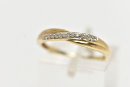 A 9CT YELLOW GOLD DIAMOND HALF ETERNITY RING, cross over style set with a row of single cut