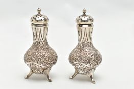 A PAIR OF WHITE METAL PEPPERETTES, baluster form, decorated with a floral and foliate pattern,