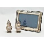A PAIR OF SILVER PEPPERETES AND A SILVER PHOTO FRAME, a pair of bluster form pepperettes, embossed