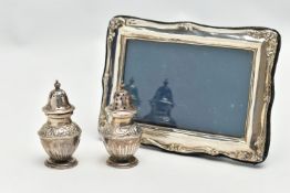 A PAIR OF SILVER PEPPERETES AND A SILVER PHOTO FRAME, a pair of bluster form pepperettes, embossed