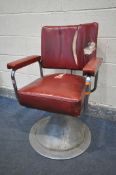 A VINTAGE RED LEATHERETTE BARBERS CHAIR, with open armrests, on a circular base (condition:-fabric