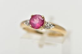 A 9CT YELLOW GOLD, RUBY AND DIAMOND RING, centering on a four claw set, circular cut ruby, flanked