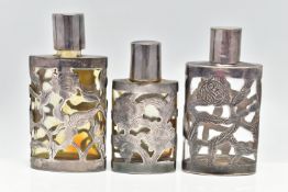 THREE MEXICAN SCENT BOTTLES, the glass bottles with pierced foliate designed cases, all stamped