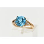 A 9CT GOLD DRESS RING, a circular cut topaz, four prong set in yellow gold, flanked with two