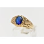 A 9CT GOLD PASTE SIGNET RING, the oval blue paste in a collet setting with engraved detail to the