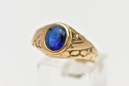 A 9CT GOLD PASTE SIGNET RING, the oval blue paste in a collet setting with engraved detail to the