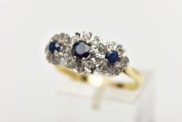 A SAPPHIRE AND DIAMOND RING, three circular cut blue sapphires, set with a surround of single cut