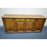 A REPRODUCTION OAK SIDEBOARD, with a plank top, two drawers over fielded panel doors, flanked by