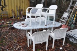 A WHITE PLASTIC GARDEN TABLE 205cm long, covered in a self adhesive cover and 6 matching chairs