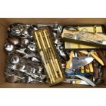 A BOX OF ASSORTED CUTLERY, to include knives, forks, cake slices, fish eaters, sugar tongs, and a