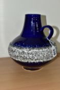 A WEST GERMAN JUG VASE, having a white fat lava glazed band on a blue ground, of bulbous form with