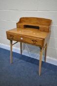 AN ERCOL ELM AND BEECH WRITING DESK, with a raised back with shelving and two drawers, above a
