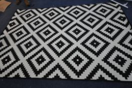 TWO PATTERNED BLACK AND WHITE RUGS, 294cm x 200cm (condition - minor stains)