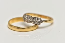 AN 18CT GOLD BAND RING AND A YELLOW METAL THREE STONE DIAMOND RING, the plain polished band,