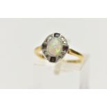 AN EARLY 20TH CENTURY OPAL DRESS RING, oval cabochon opal, within a surround of eight single cut