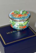 A BOXED MOORCROFT ENAMELS TRINKET BOX, of cylindrical form, decorated with sprigs of fir, fir cones,