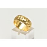 A WIDE YELLOW METAL TEXTURED BAND, approximate band width 7.6mm, stamped 18ct, ring size centre N,