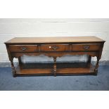 A REPRODUCTION OAK DRESSER BASE, with three frieze drawers, on turned front legs, united by an under