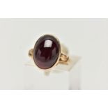 A 9CT YELLOW GOLD GARNET SINGLE STONE RING, the oval garnet cabochon, within a collet setting, to