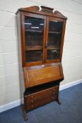 AN EARLY 20TH CENTURY OAK GLAZED BOOKCASE, with a fall front door, enclosing a fitted interior,