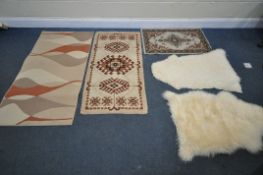 A SELECTION OF RUGS, to include two sheepskin rugs, and three other modern rugs (5)