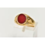 A YELLOW METAL SIGNET RING, inlay set with carnelian, leading onto a tapered yellow metal band,