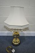 A BRASS TABLE LAMP, with a cream fabric shade, and a bulbous shaft, on a wooden base, height 60cm