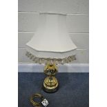 A BRASS TABLE LAMP, with a cream fabric shade, and a bulbous shaft, on a wooden base, height 60cm
