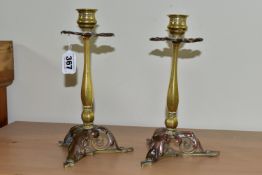 A PAIR OF BRASS AND COPPER CANDLESTICKS, in the form of flowers with foliate scrolling bases