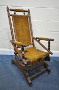 AN EDWARDIAN WALNUT AMERICAN ROCKING CHAIR (condition:-fabric worn and fraying)