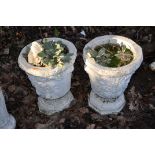 A PAIR OF TWO PIECE COMPOSITE GARDEN URNS with foliate detail to bowl height 50cm