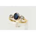 A YELLOW METAL SAPPHIRE AND DIAMOND RING, centering on an oval cut deep blue sapphire, collet set,