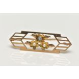 AN EARLY 20TH CENTURY GOLD BROOCH, open work brooch with floral detail, set with two seed pearls and