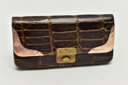 AN EARLY 20TH CENTURY CROCODILE SKIN PURSE, mounted with two 9ct rose gold hard wear corners to