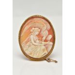 A YELLOW METAL CAMEO BROOCH, of an oval form, carved shell cameo depicting Hebe and Zeus in eagle