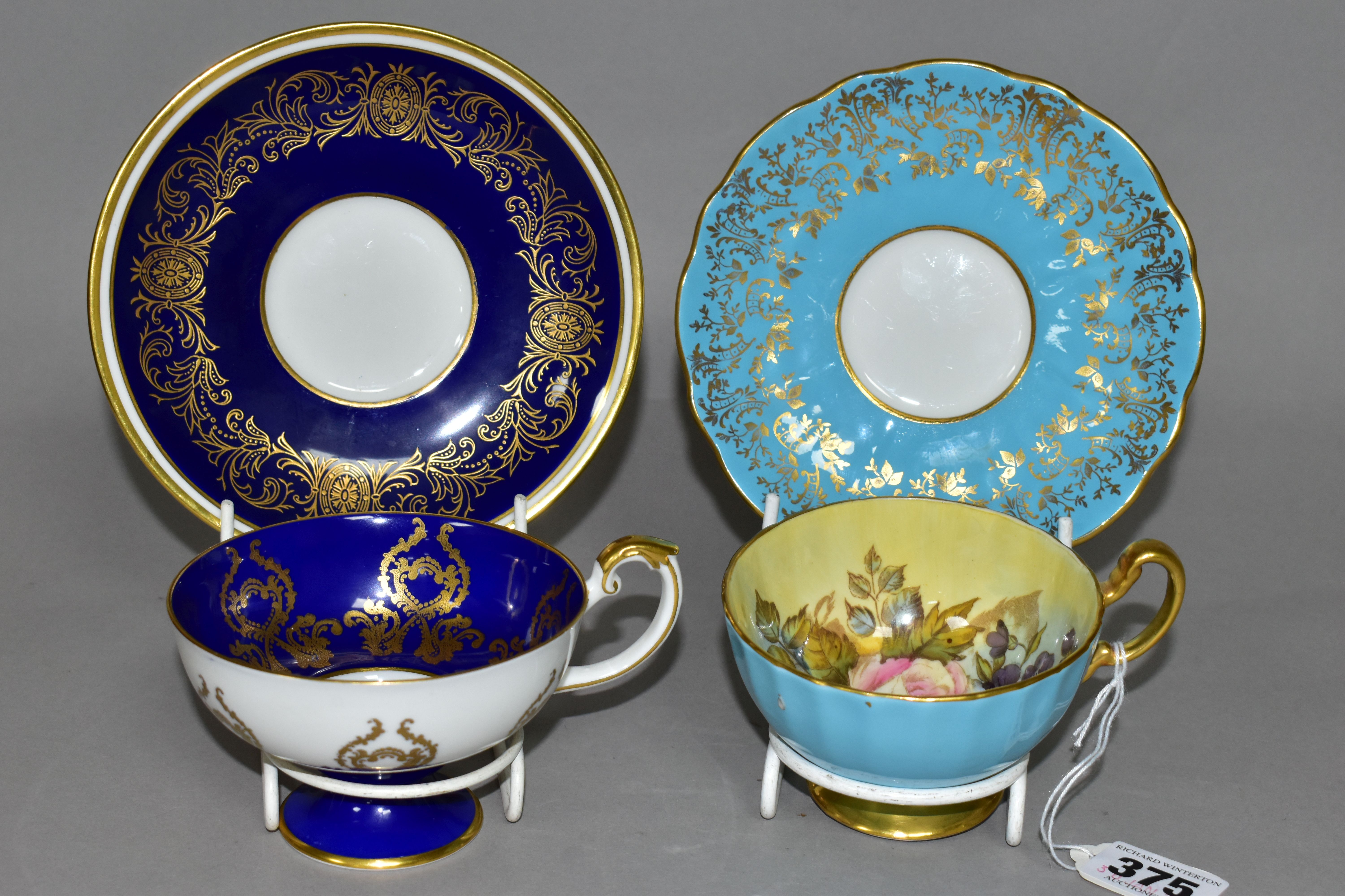TWO AYNSLEY CABINET TEACUPS AND SAUCERS, comprising a turquoise cup and saucer, the interior of