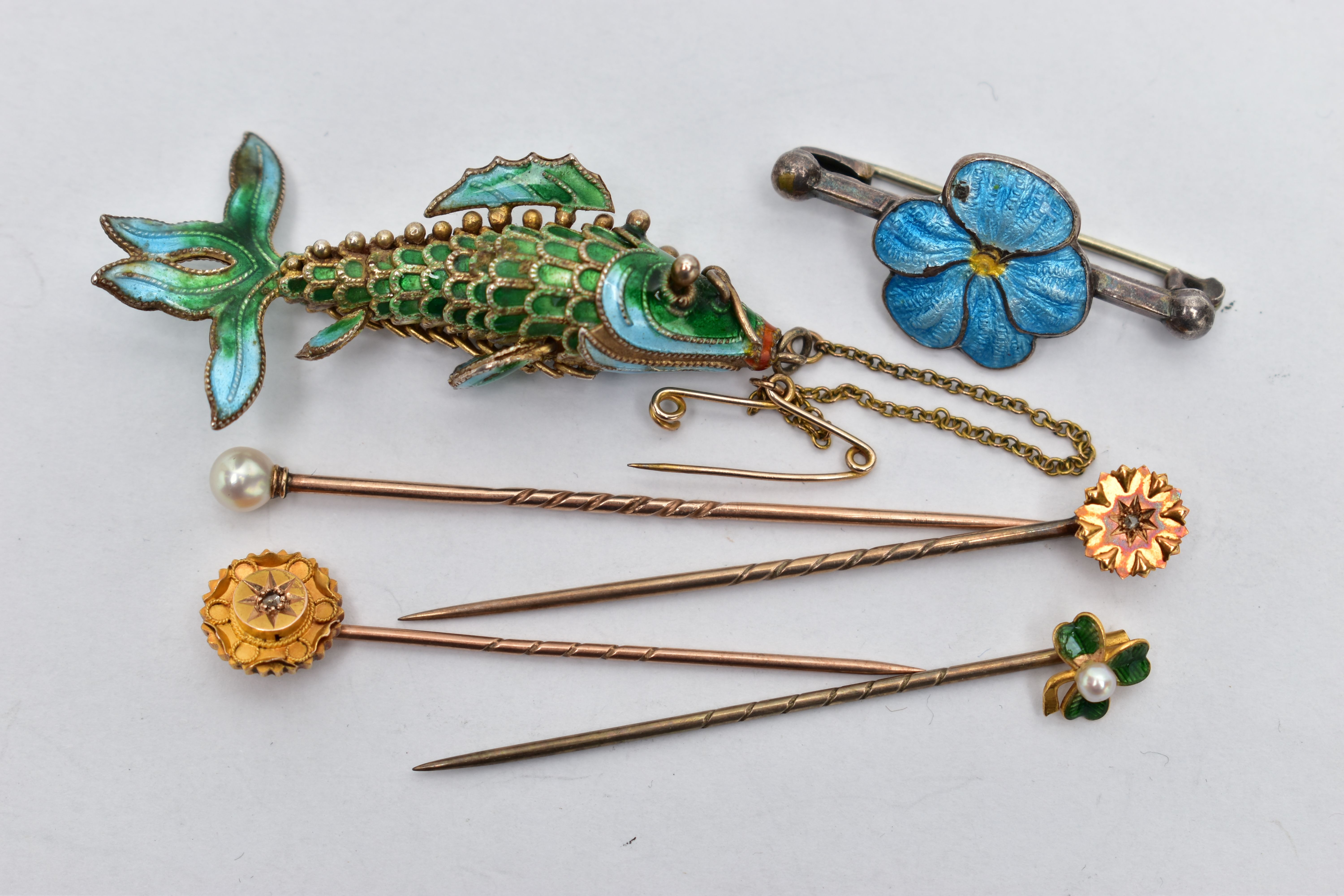 SIX ITEMS OF JEWELLERY, to include an articulated enamel fish, a blue enamel flower bar brooch, a