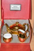 A BOXED ROYAL WORCESTER GOLD LUSTRE THREE PIECE TEA SET, teapot shape 5, size 4, milk jug and