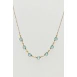 A MID 20TH CENTURY YELLOW METAL NECKLACE, set with seven pale blue square cut pastes, each claw