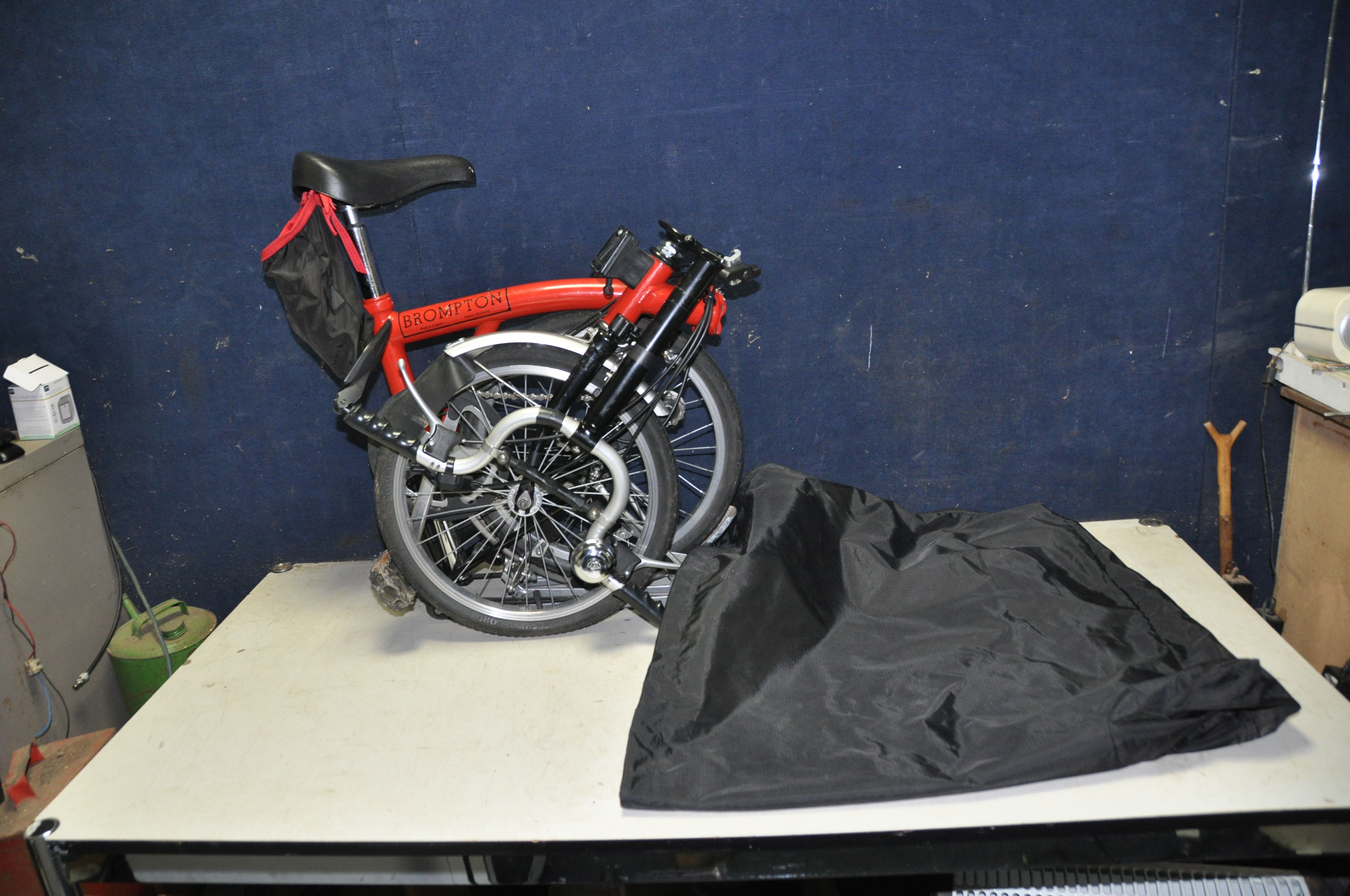 A BROMPTON FOLDING BIKE WITH BAG in red
