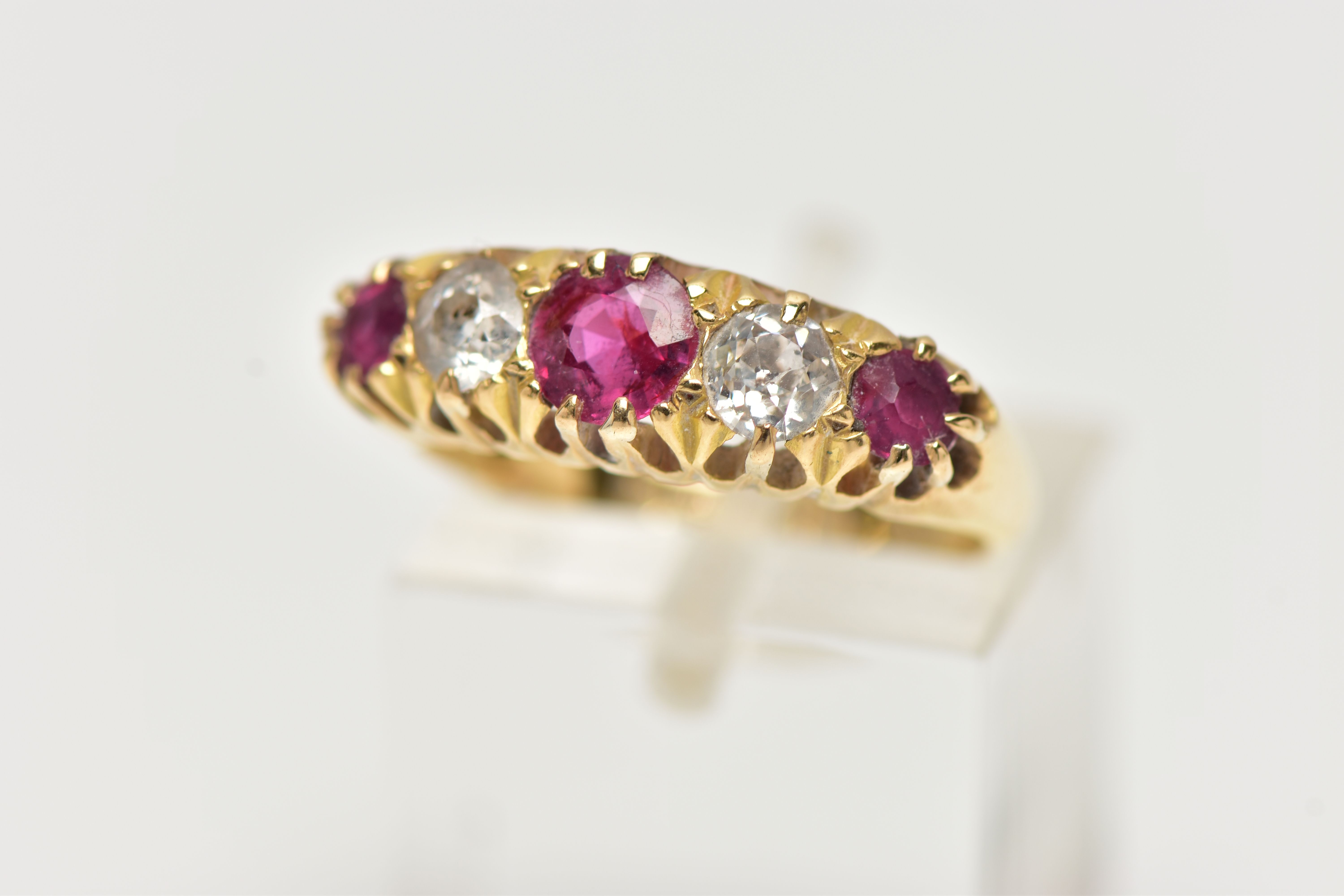 AN EARLY 20TH CENTURY 18CT GOLD, RUBY AND DIAMOND RING, designed with three circular cut rubies,