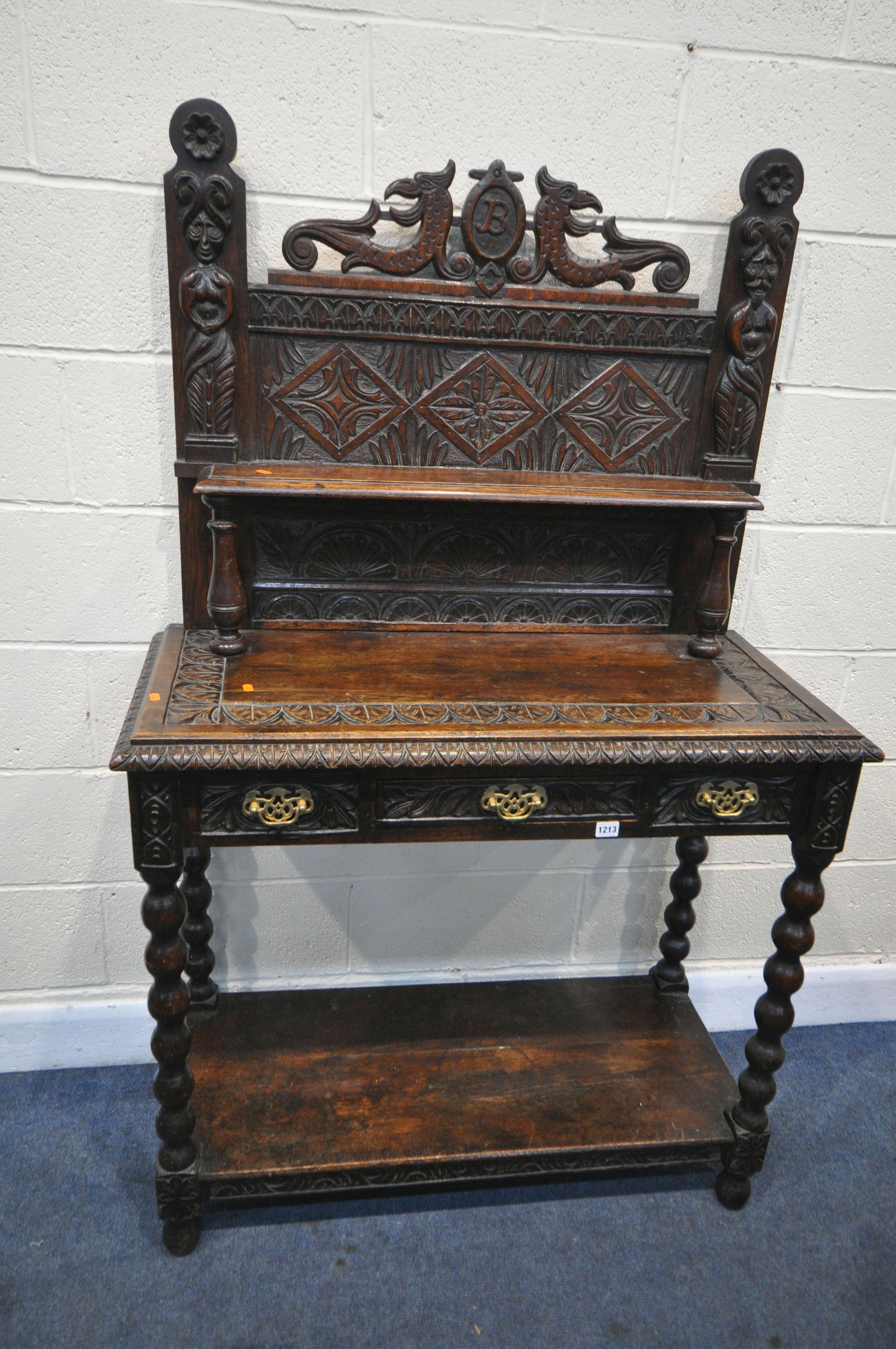 A LATE 19TH/EARLY 20TH CENTURY CARVED OAK SIDE TABLE, the raised back with a single shelf, depicting