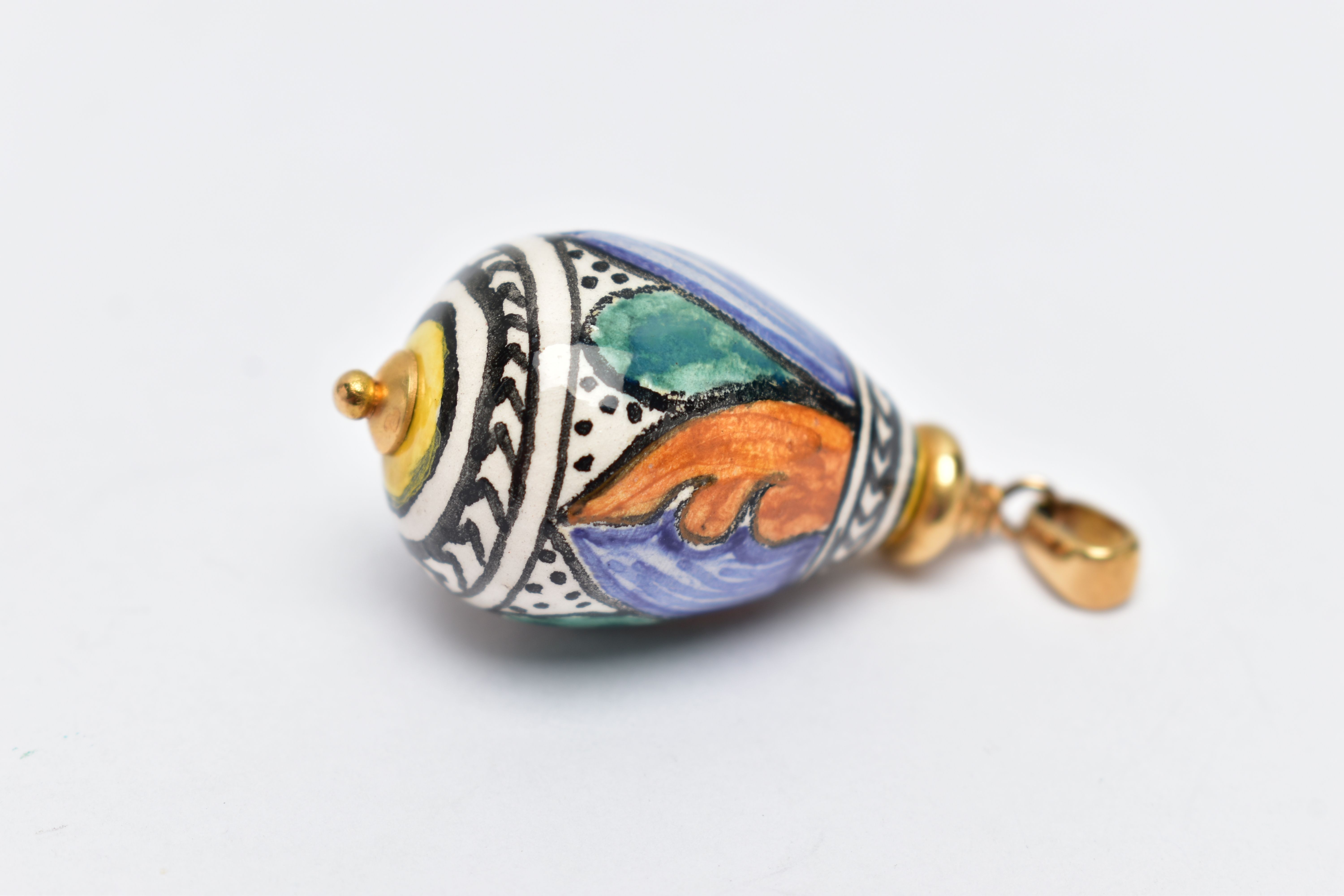 A YELLOW METAL AND CERAMIC PENDANT, polychrome ceramic tear drop pendant detailed with green,