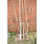 A COLLECTION OF GARDEN TOOLS to include rakes, spade, pick axe, sledge hammer, loppers etc